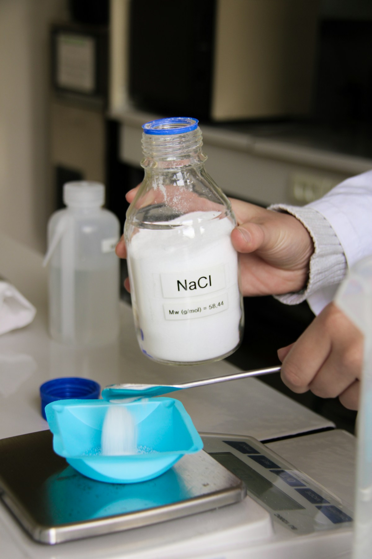 Laboratory technician measuring an ingredient on a precision scale